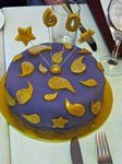 Purple-iced cake with gold stars and paisleys